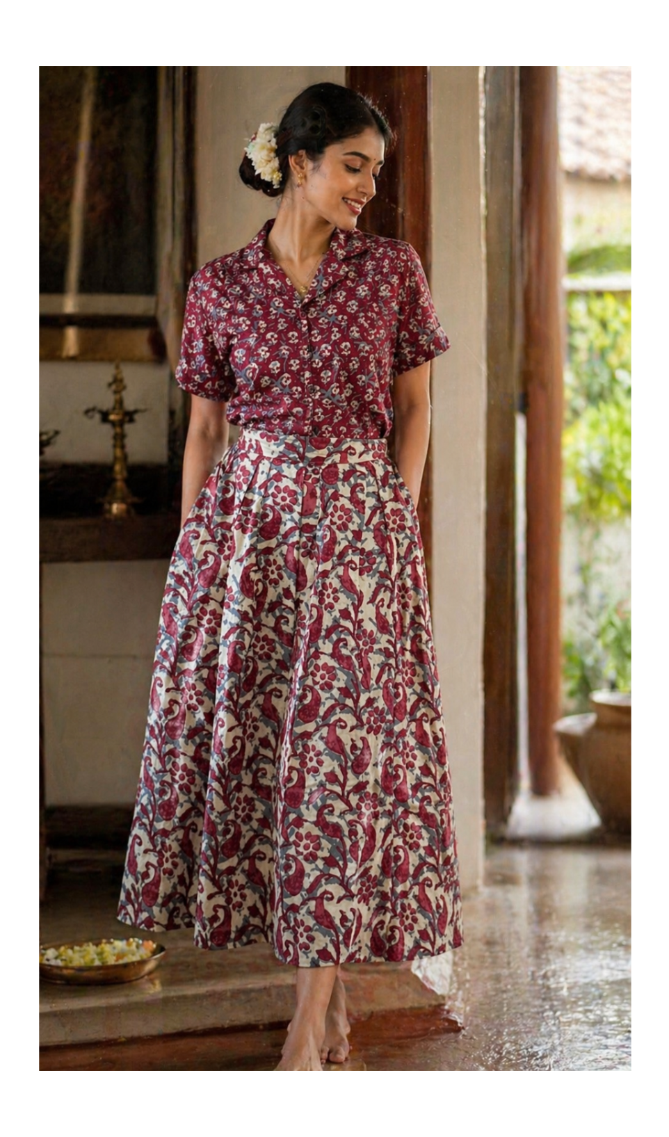 Woman wearing a floral dress standing in a doorway with a garden view.